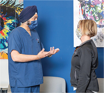 Bonnie Amann, receptionist (right), consults with Dr. Singh.