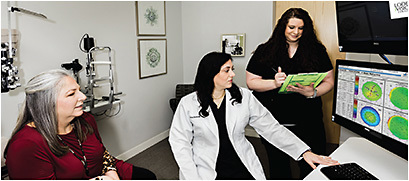 Iwaz Barwari, physician assistant, and Lauren Poole, technician, showing Pentacam results to review astigmatism with a patient.